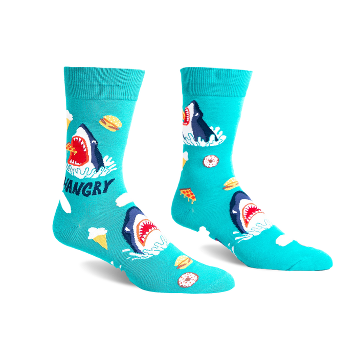 Pair of teal crew socks with a graphic design of a hungry shark surrounded by pizza, ice cream, and burgers.