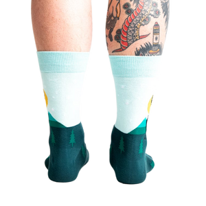 Back view of the Star Buck socks on a person's legs, highlighting the design's continuation around the heel and ankle.