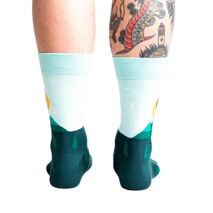 Back view of the Star Buck socks on a person's legs, highlighting the design's continuation around the heel and ankle.