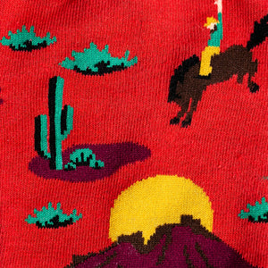 Close-up detail shot of the sock's fabric, emphasizing the color details and design elements like the cacti and sunset.
