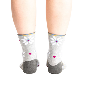 Back view of the socks on a model, showing the design detail on the heel and cuff.