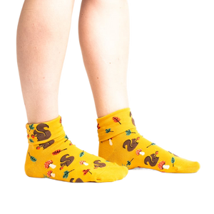 Lifestyle photo: Person's legs wearing the mustard yellow 'I'm Fallin' for You' socks.