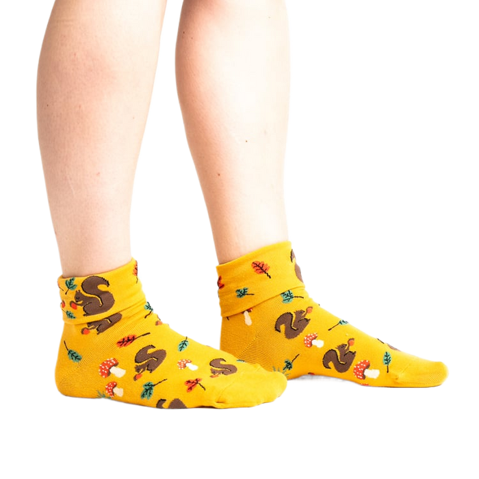 Lifestyle photo: Person's legs wearing the mustard yellow 'I'm Fallin' for You' socks.