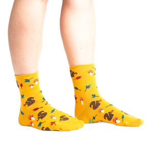 Lifestyle photo: Person's legs wearing the mustard yellow 'I'm Fallin' for You' socks.