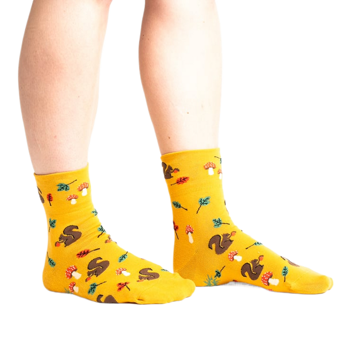 Lifestyle photo: Person's legs wearing the mustard yellow 'I'm Fallin' for You' socks.