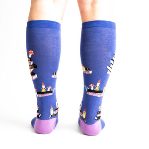 Rear view of model wearing the 'Reading is Magic' knee-high socks, showcasing the full design on both legs.