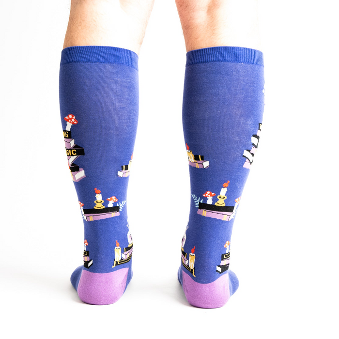 Rear view of model wearing the 'Reading is Magic' knee-high socks, showcasing the full design on both legs.
