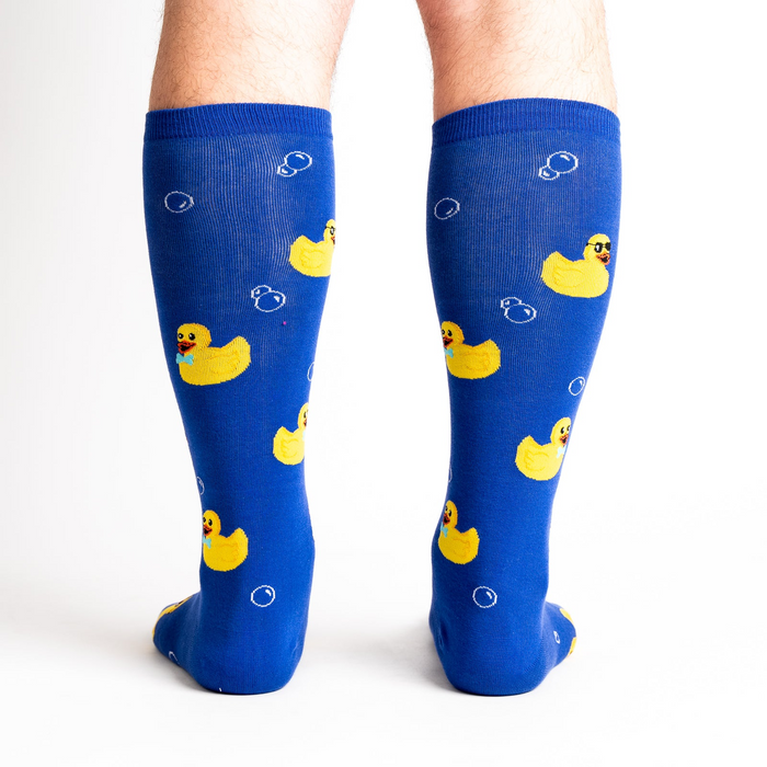 Rear view of a model's legs wearing the blue rubber duckie knee-high socks.