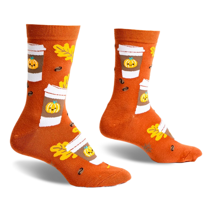 Pair of crew socks in burnt orange featuring a pattern of pumpkin spice latte cups, autumn leaves, and coffee beans.