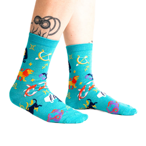 Lifestyle shot of a person wearing the teal zodiac socks.