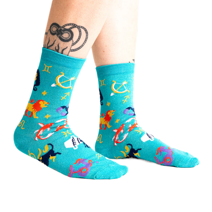 Lifestyle shot of a person wearing the teal zodiac socks.