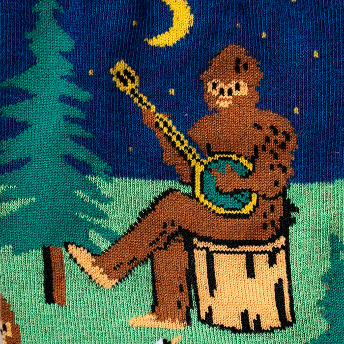 Close-up detail shot showcasing the Bigfoot playing a banjo on the Sasquatch Campout socks.