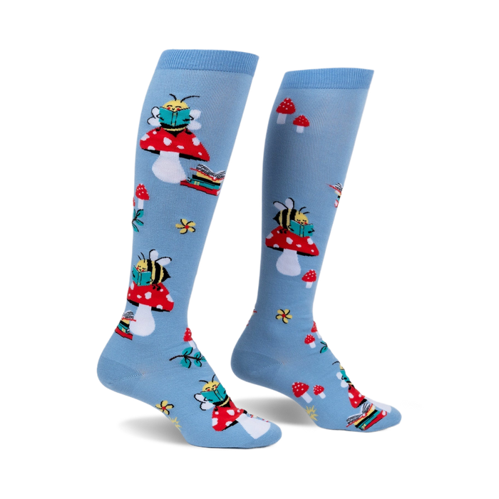 Pair of light blue knee-high socks with a whimsical design featuring bees reading books perched on red mushrooms.