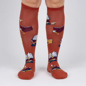 Front view: Pair of burnt orange True Crime knee-high socks on a light grey background.