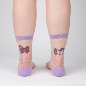 Rear view of the 'Wrapped in a Bow' socks on a model's legs showcasing the sock's design and fit from behind.