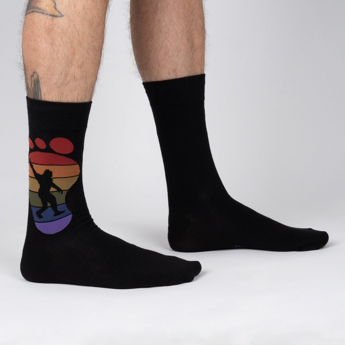 Lifestyle shot showing the 'Squatch and Learn' socks on a person's feet, showcasing the fit and design.
