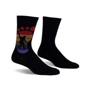 Black crew socks with a rainbow-colored Bigfoot footprint design.  The Bigfoot is silhouetted and holding up a peace sign.