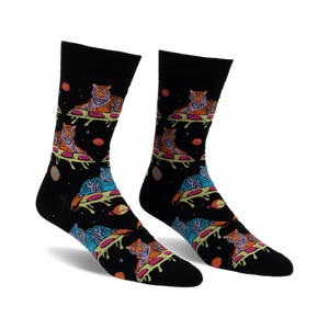 Pair of black crew socks with a fun design featuring tigers sprawled on pizza slices amidst planets and stars. Multicolored tigers and space elements on a dark background.