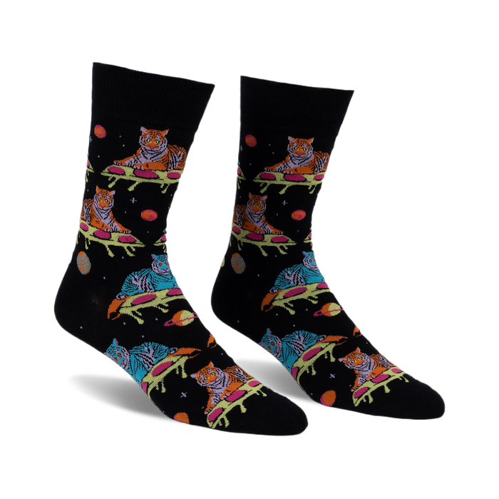 Pair of black crew socks with a fun design featuring tigers sprawled on pizza slices amidst planets and stars. Multicolored tigers and space elements on a dark background.