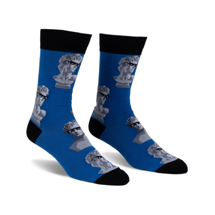 Pair of blue crew socks with a pattern of grey marble busts wearing sunglasses. Black cuffs.