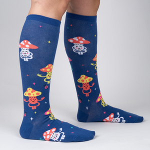 Lifestyle shot showing the socks on a person's legs.  The socks are navy blue with a fun mushroom pattern.