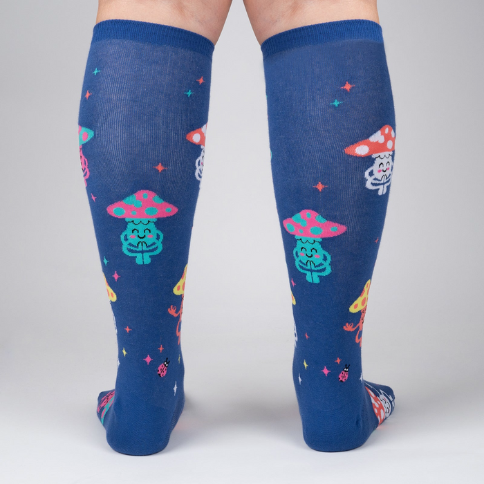 Rear view of a person wearing the navy blue knee-high socks with meditating mushrooms.
