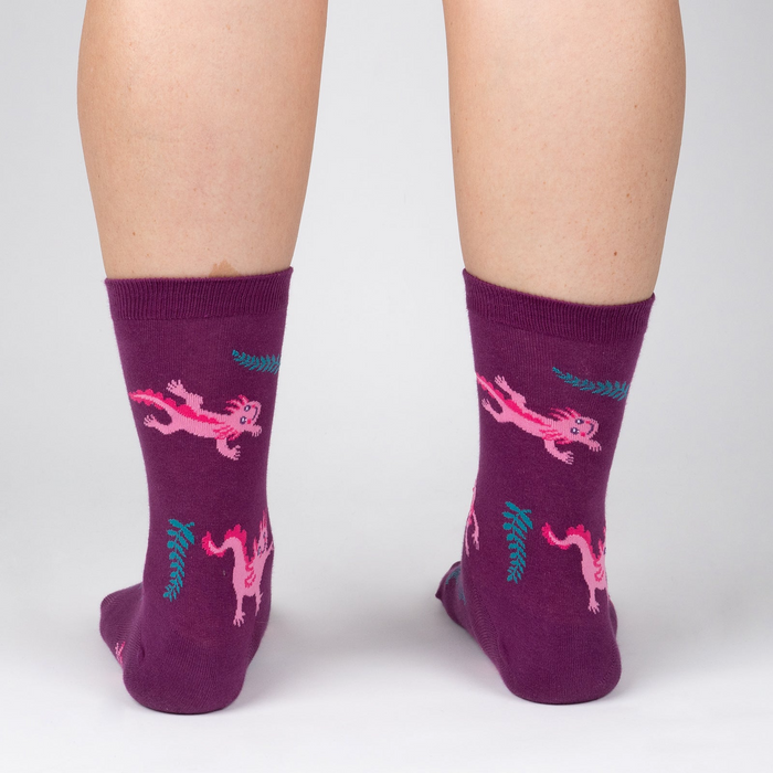 Back view of a person wearing Relaxolotl socks, showcasing the axolotl and fern pattern.