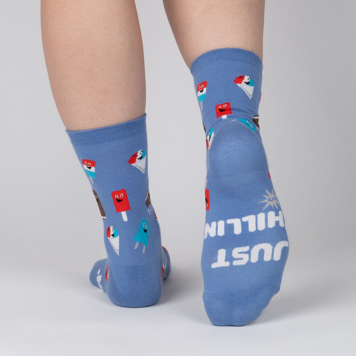 Rear view of periwinkle blue crew socks; the words 'JUST CHILLIN' are spelled out on one heel.