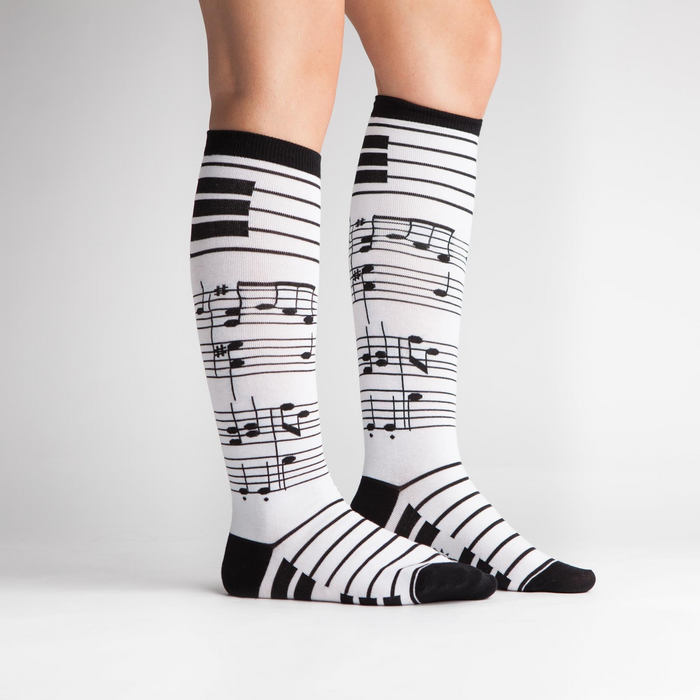 Woman's legs modeling the black and white musical note knee-high socks.