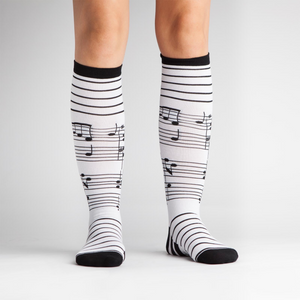 Close-up view of the black and white musical note knee-high socks laid flat.