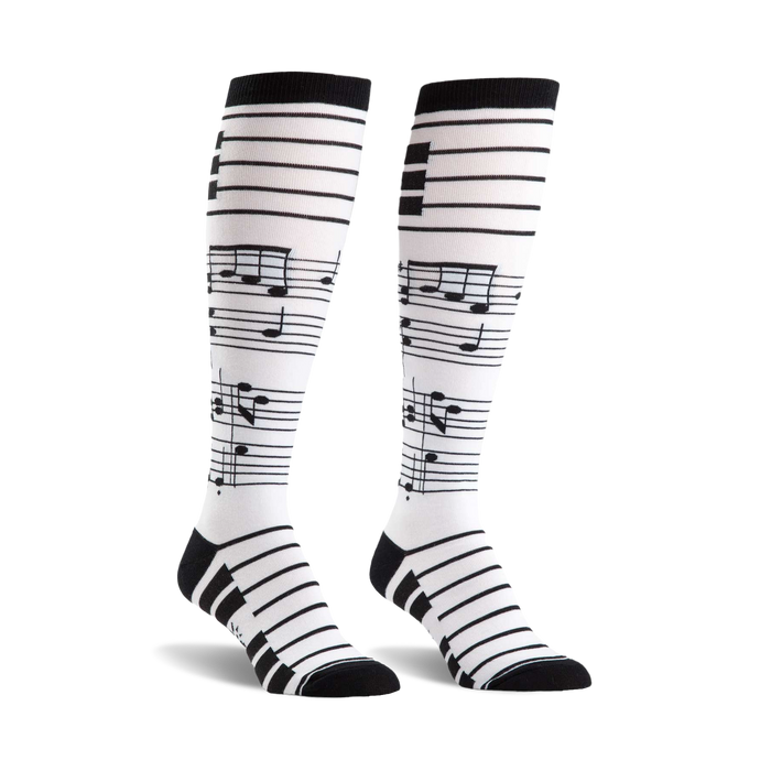Pair of black and white knee-high socks.  The socks have a musical staff and notes design.