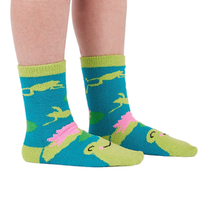 A person's legs and feet wearing the fuzzy teal blue slipper socks, shown from the side.