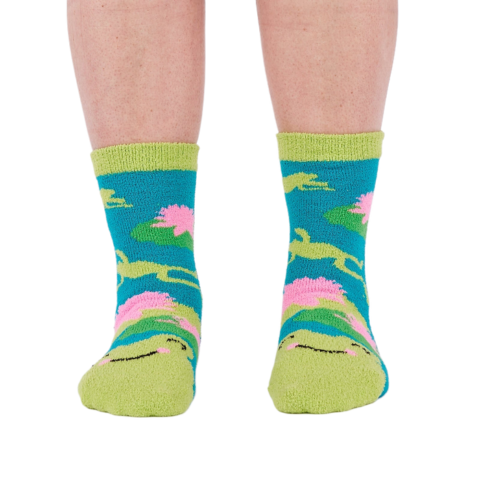 A person's legs and feet, viewed from the front, wearing the fuzzy teal blue slipper socks.