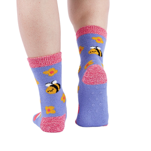 Person wearing fuzzy periwinkle slipper socks, back view, showing the anti-slip grippers on the sole.