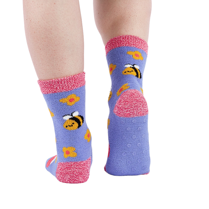 Person wearing fuzzy periwinkle slipper socks, back view, showing the anti-slip grippers on the sole.