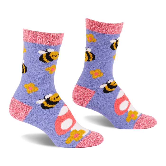 Pair of fuzzy periwinkle slipper socks with pink cuffs, heels, and toes, patterned with yellow bees, mushrooms, and flowers.