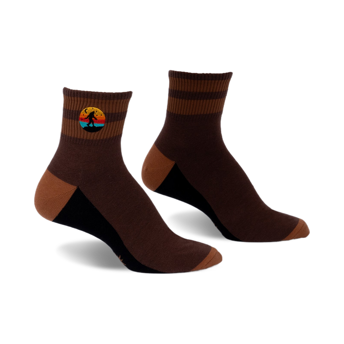 Pair of brown and tan striped ankle socks with a small embroidered Bigfoot in a retro sunset design.