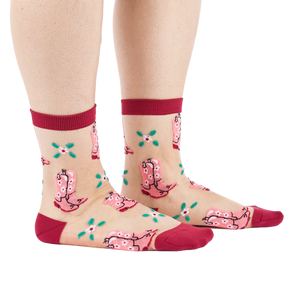 A person's legs and feet, wearing sheer pink cowboy boot socks from the side. Legs are bare against a white background.