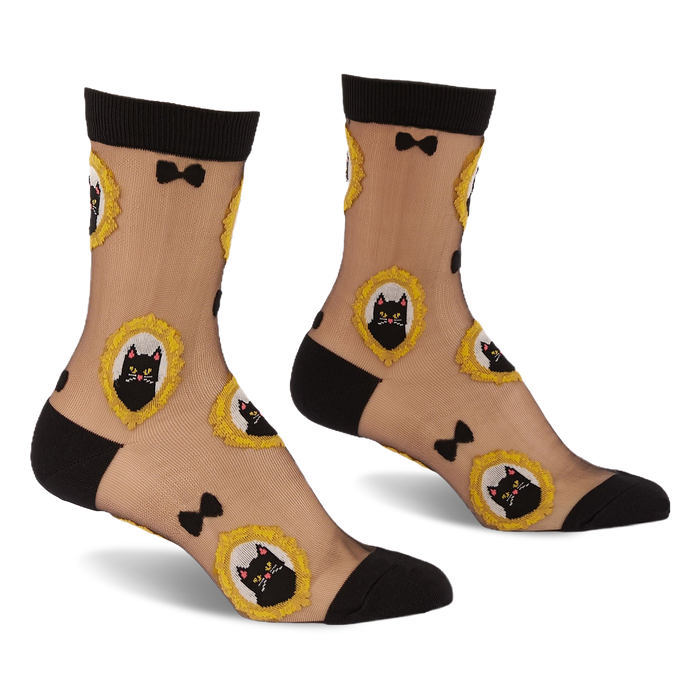 Sheer ankle socks with black cuffs, heels, and toes. Feature black cat faces in frilly gold frames and small black bows.