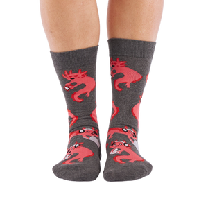 Full-length shot of a person's legs, viewed from the front, wearing grey axolotl gaming crew socks on a white background.