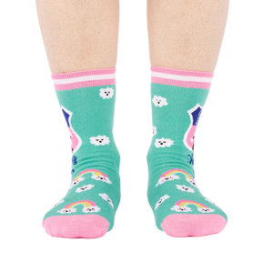 Front view of a person's legs wearing teal 'Hiking Club' crew socks. Both socks display the cloud pattern and 'Out of Breath' text.