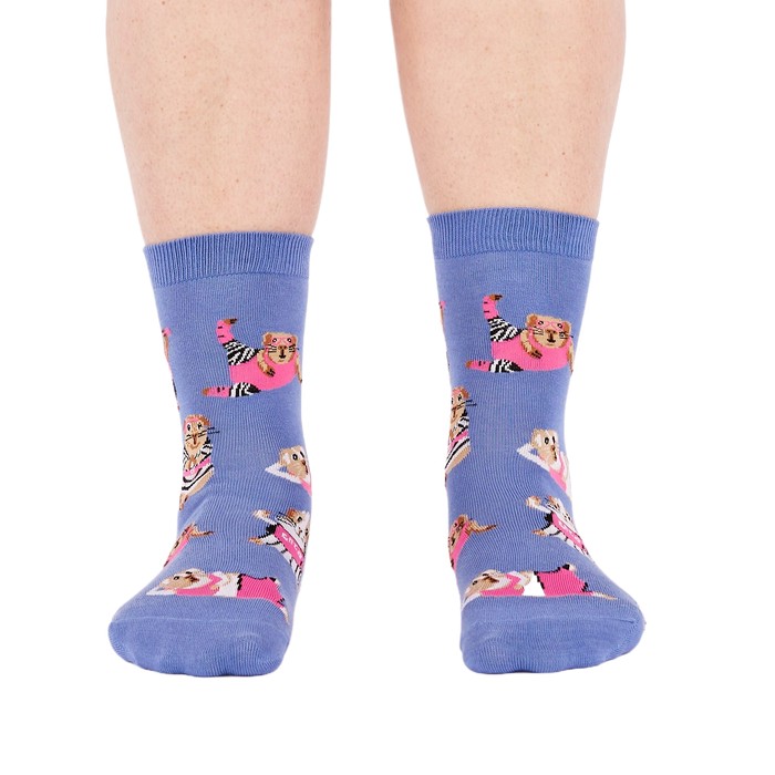 Person's feet wearing periwinkle crew socks with a guinea pig workout pattern, viewed from the front on white.