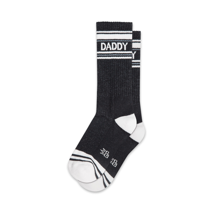 Pair of black crew socks with white stripes and 'DADDY' text.  Sporty and playful design.