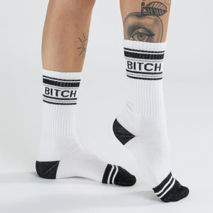 Lifestyle shot of 'Bitch' socks on a woman's legs, showcasing the fit and style.