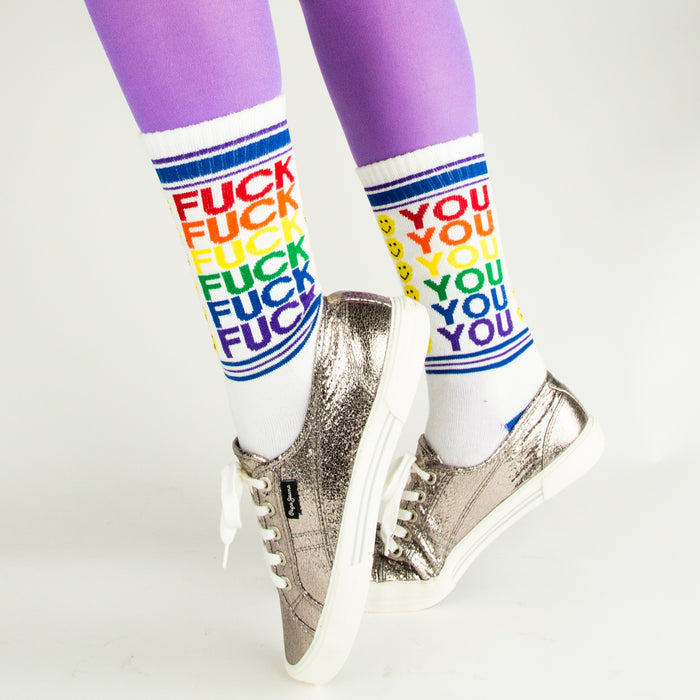 Lifestyle shot of model wearing 'Fuck You' socks with silver sneakers and purple tights.