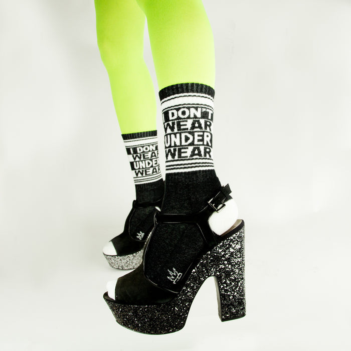 Lifestyle shot: Model wearing neon green tights and black platform shoes with the 'I Don't Wear Underwear' socks.