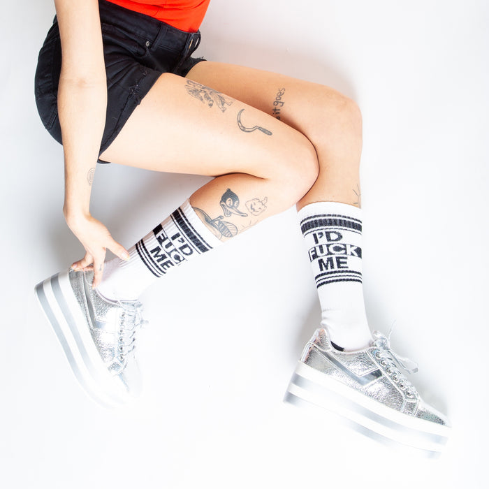 Lifestyle shot: Person wearing white 'I'd Fuck Me' socks with silver platform shoes.
