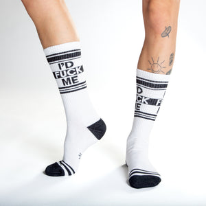 Close-up shot of a person's legs wearing white 'I'd Fuck Me' socks and silver platform shoes.