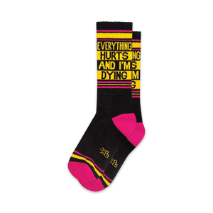 Pair of crew socks in black and hot pink with yellow text reading 'Everything Hurts And I'm Dying'.