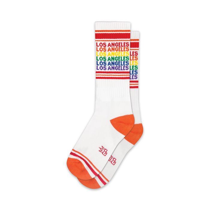 Pair of white crew socks with orange cuffs and rainbow-colored 'Los Angeles' text. }}